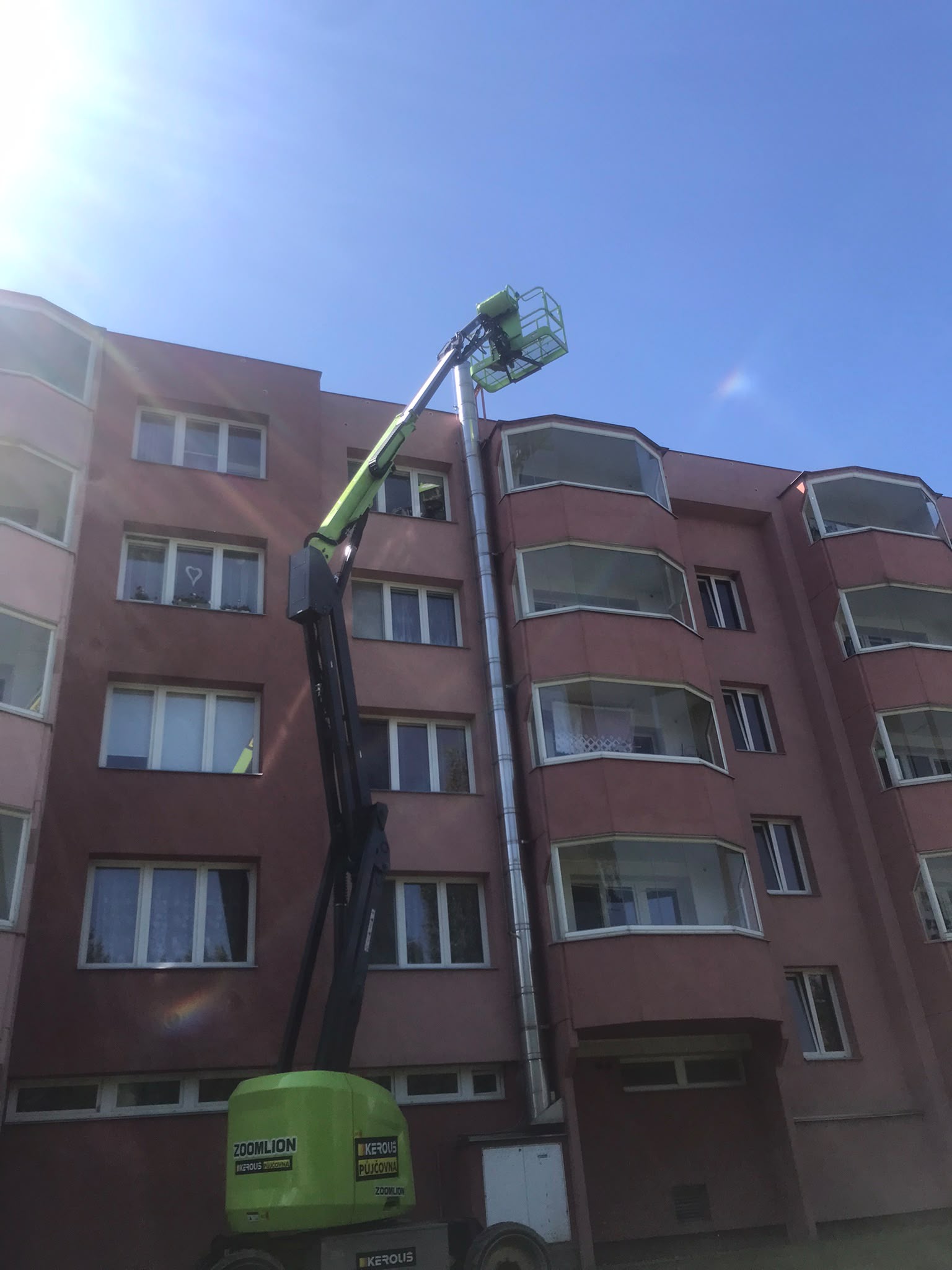 Práce na bytovém domě z pracovní plošiny